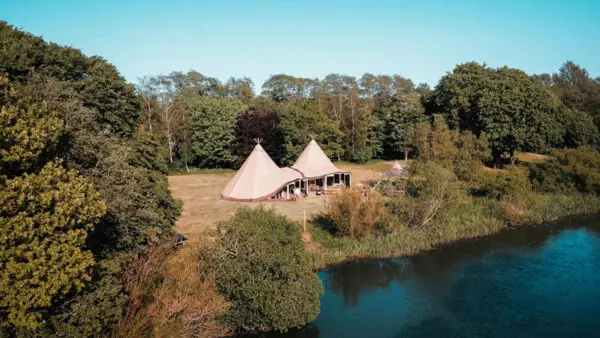 Tipi entre les arbres, avec une rivière qui passe devant ,de quoi trouver la tranquillité
